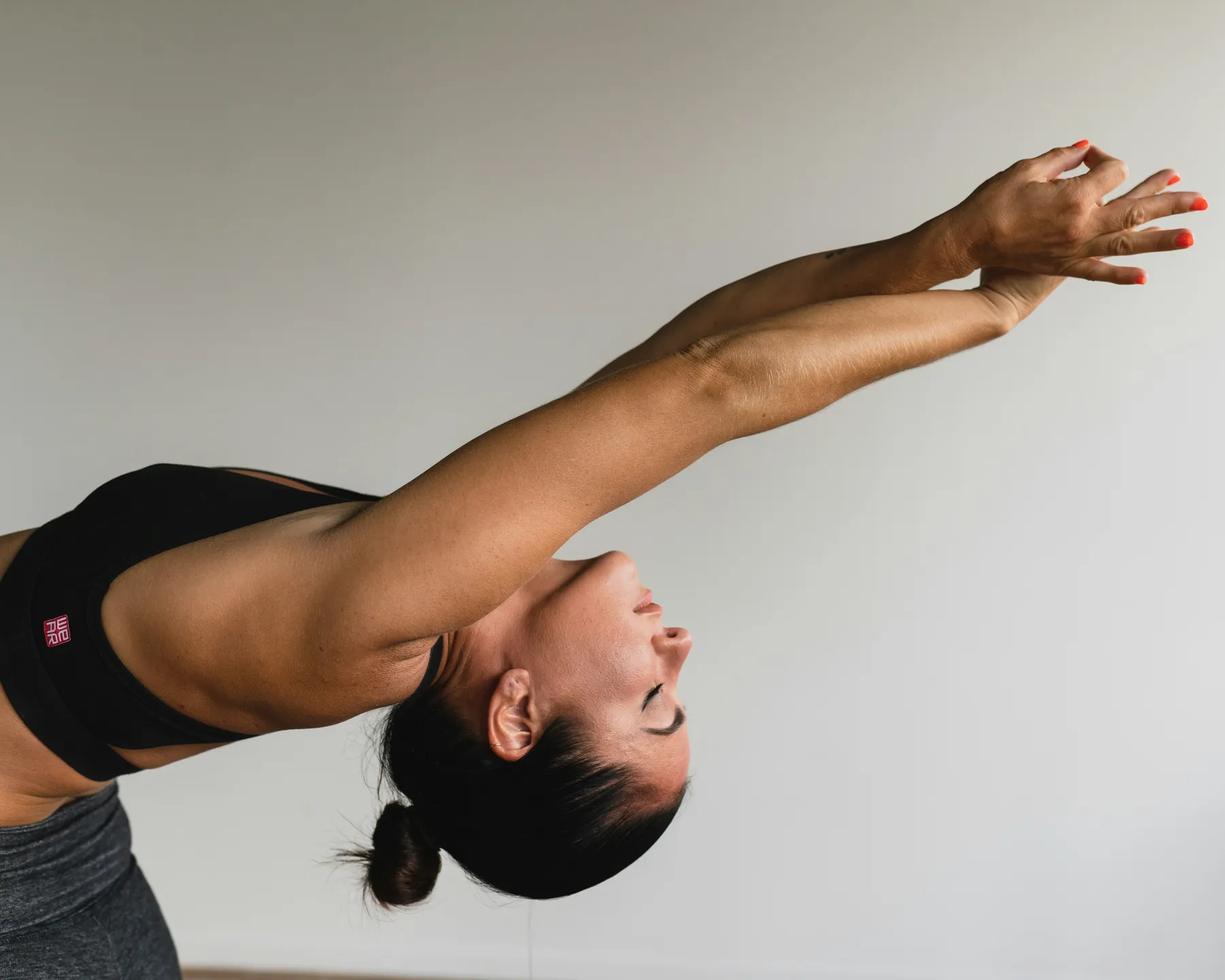 Woman stretching backward with one arm reaching overhead