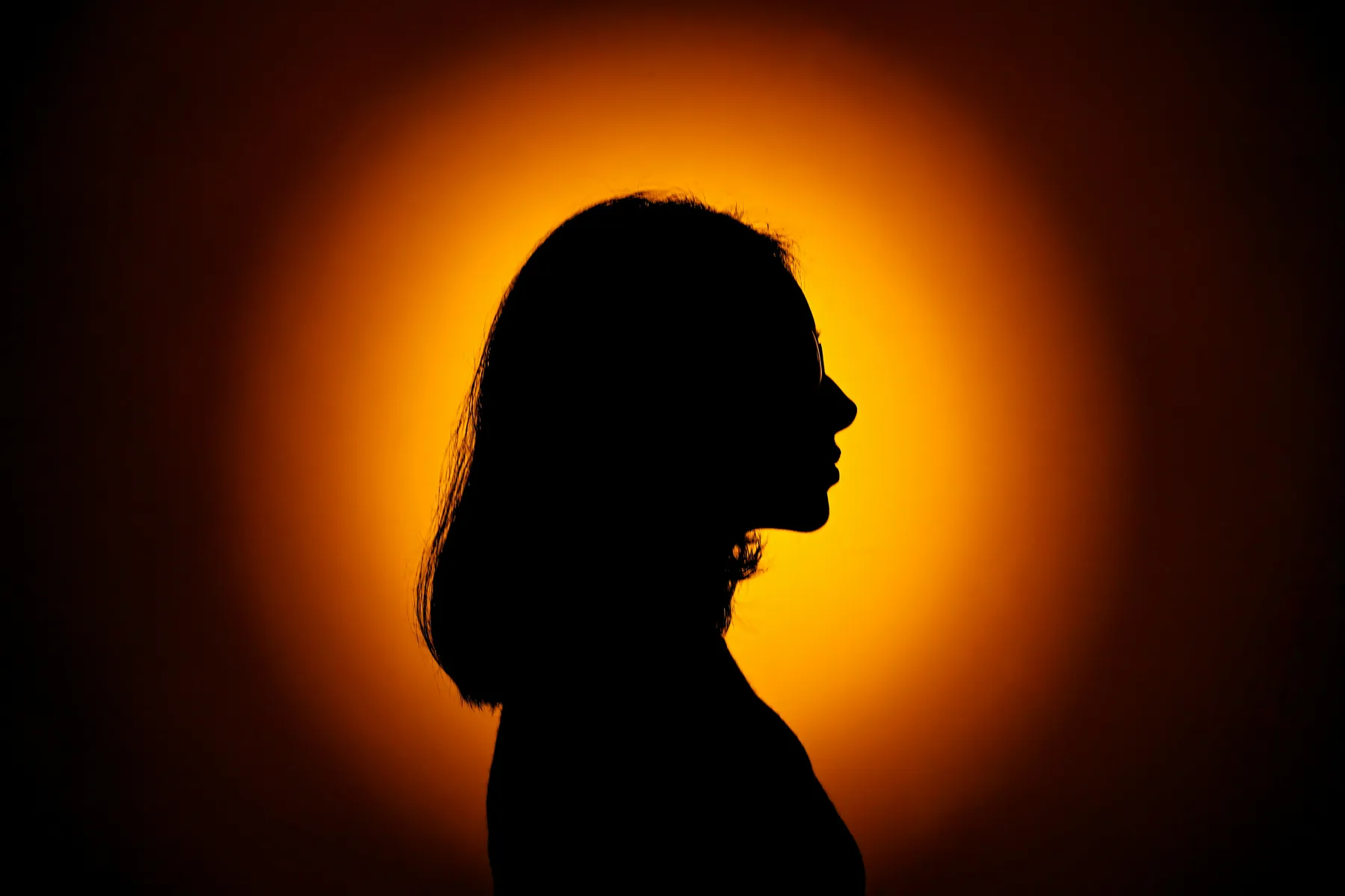 Silhouette of a woman against a red moon